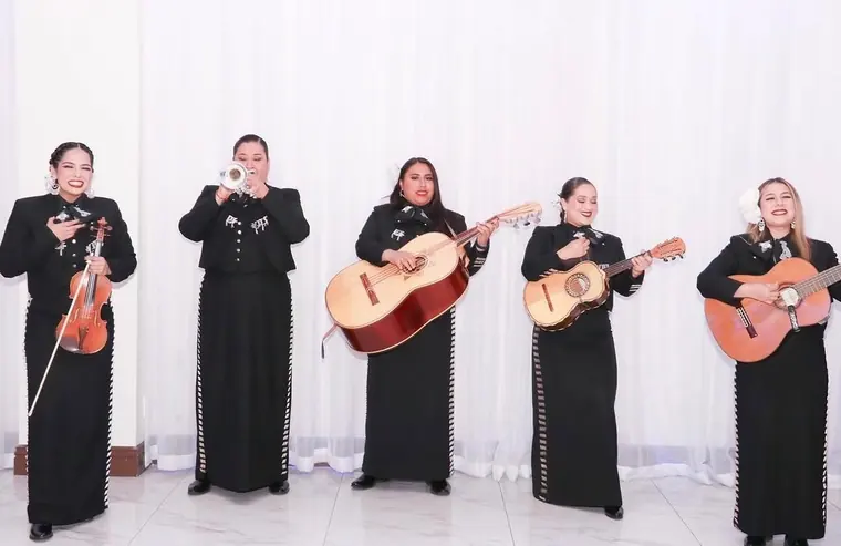 All-female mariachi group performing in black charro suits